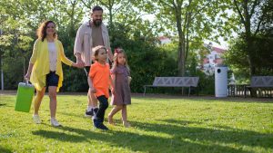 A joyful family with children strolling in a sunny Portuguese park.